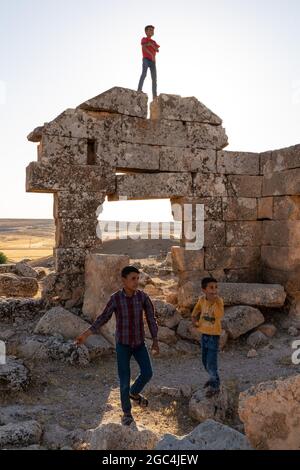 Dorfkinder spielen zwischen den Ruinen der historischen Stadt Shuayip, bekannt als Ozkent Dorf, das dem Propheten Shuayb gemunkelt wird. Stockfoto