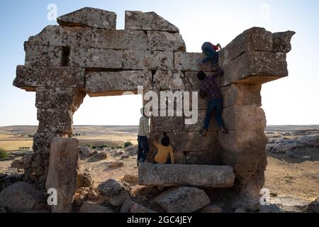 Dorfkinder spielen zwischen den Ruinen der historischen Stadt Shuayip, bekannt als Ozkent Dorf, das dem Propheten Shuayb gemunkelt wird. Stockfoto