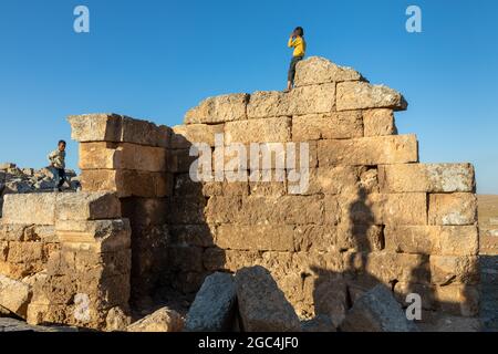 Dorfkinder spielen zwischen den Ruinen der historischen Stadt Shuayip, bekannt als Ozkent Dorf, das dem Propheten Shuayb gemunkelt wird. Stockfoto