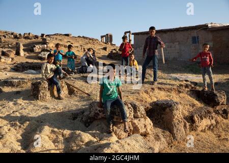 Dorfkinder spielen zwischen den Ruinen der historischen Stadt Shuayip, bekannt als Ozkent Dorf, das dem Propheten Shuayb gemunkelt wird. Stockfoto