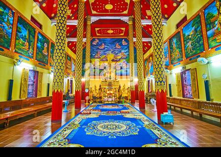 LAMPANG, THAILAND - 8. MAI 2019: Das farbenfrohe Innere von Viharn im Wat Suan Dok mit goldenem Buddha auf dem Altar und vielen Wandmalereien an den Wänden, am Mai Stockfoto