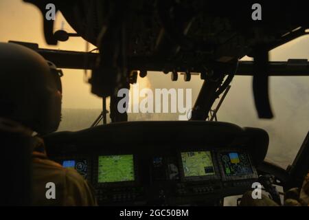 Oregon Army National Guard Blackhawk Pilot im Kommando, Chief Warrant Officer 4 Joe Zeiner, (links) von G/1-189 Aviation (MEDEVAC) aus Salem, Oregon, nähert sich einer riesigen Rauchwolke im Flug für Luftwassertropfenoperationen, Eastern, Oregon, 22. August 2020. Die Hubschrauber werden für einen Zeitraum von zwei Wochen aktiviert und unterstützen das Oregon Department of Forestry und lokale Behörden bei Waldbränden, die derzeit in Ost-Oregon stattfinden. (Foto der Oregon National Guard von Tech. Sgt. Aaron Perkins, Oregon Military Department) Stockfoto