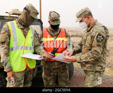 Oregon Army National Guard Spc. Russell Baghdadi, Staff Sgt. Randy Bowman und 2nd LT. Sky Smith, alle mit 1. Staffel, 82. Kavallerie-Regiment, arbeiten zusammen, um die Dienstpläne der Bewohner an einem Verkehrskontrollpunkt (TCP), Warm Springs, Oregon, zu überprüfen., 17. September 2020. Das Feuer in Lionshead, das sich 14 Meilen westlich von Warm Springs befindet, könnte potenziell zu einer Evakuierung führen und die Häuser verwundbar lassen. Soldaten des 82nd Cavalry Regiments, das auf vier TCPs entlang des US Highway 26 stationiert ist, helfen den lokalen Bürgern zu beruhigen und jeden zu überwachen, der in die Nachbarschaft eindringt und sie verlässt. Stockfoto