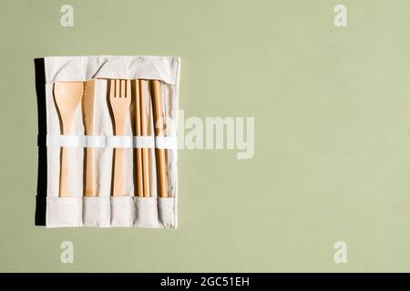Set aus umweltfreundlichem Bambus-Besteck auf grünem Hintergrund. Nachhaltiger Lebensstil. Kunststofffreies Konzept. Zero Waste Konzept. Für Text platzieren Stockfoto