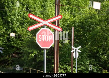 Bild eines Verkehrszeichens, das auf eine Eisenbahnlinie und einen Bahnübergang hinweist. Dieses Signal, auch St Andrews Cross oder Crossbuck genannt, ist typi Stockfoto