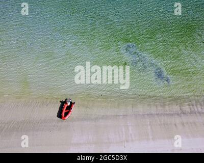 Luftaufnahme des roten Schlauchbootes am Strand, Oyster Bay, Brampton Island, Whitsunday Islands National Park, Queensland, Australien. Keine PR Stockfoto