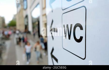 06. August 2021, Sachsen, Leipzig: Ein Schild weist den Weg zu einer öffentlichen Toilette in der Innenstadt. Die großen Städte sind in der Regel für die kleinen menschlichen Bedürfnisse ausgestattet. Die ruhigen kleinen Toiletten sind jedoch nicht immer leicht zu finden oder werden durch Vandalismus zerstört. In Leipzig sind öffentliche Toiletten derzeit knapp beet. Die öffentlichen Werbeverträge für den Weltraum aus den frühen 1990er Jahren sind abgelaufen. Nun werden die 20 Toiletten eines neuen Betreibers Schritt für Schritt aufgebaut. (Zur wöchentlichen Umfrage von dpa 'Neue Konzepte und Betreiber sollten die Versorgung mit Toiletten verbessern' aus dem Jahr 07.08.2021) Foto: Sebastian Willnow/dpa-Zentralbild/dpa Stockfoto