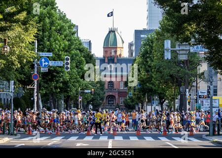 Sapporo, Japan. August 2021. Die Läufer passieren vor dem Red Brick Building, dem ehemaligen Hokkaido-Regierungsbüro, in der Innenstadt von Sapporo Leichtathletik: Frauen-Marathon während der Olympischen Spiele in Tokio 2020 im Sapporo Odori Park in Sapporo, Japan . Kredit: Takeshi Nishimoto/AFLO SPORT/Alamy Live Nachrichten Stockfoto