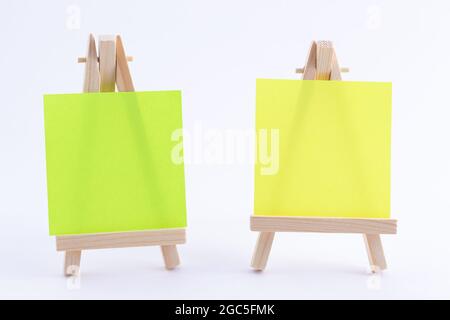 Zwei hölzerne Easels Miniature mit blanker quadratischer Leinwand oder Memopapier - Mockup. Mini-Holzständer mit sauberer Zeichenfläche auf weißem Hintergrund, Copy Space Stockfoto