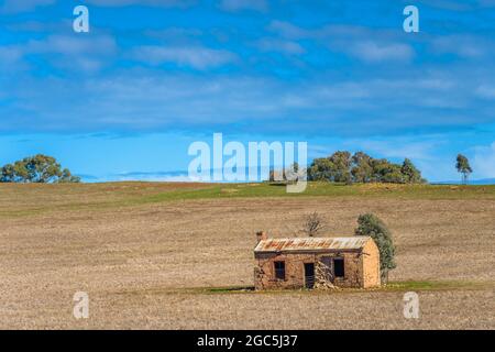 Ein verlassener, denkmalgeschützter Pionier, Steingehöft liegt auf einem gepflügten Feld auf einem sanft abfallenden Hügel in der Nähe von Burra in Südaustralien. Stockfoto