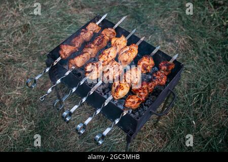 Schaschlik oder Schaschlik ein Gericht mit Spießen und gegrillten Fleischwürfeln. Traditionelle russische und kaukasische Küche. Camping Essen Stockfoto