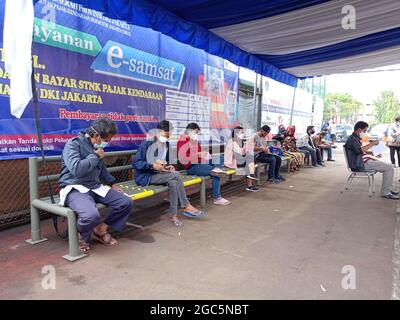 Editorial Photo, Indonesien, East Jakarta, Samsat Office, 06. August 2021, Personen in der Nähe von Bus Samsat Keliling, STNK, jährliche Steuer, One Stop Administration Stockfoto