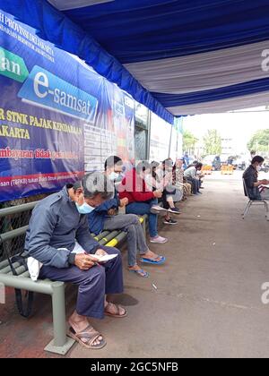 Editorial Photo, Indonesien, East Jakarta, Samsat Office, 06. August 2021, Personen in der Nähe von Bus Samsat Keliling, STNK, jährliche Steuer, One Stop Administration Stockfoto