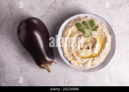 Baba ganoush Levantine Cuisine Vorspeise aus gebackenen Auberginen und Sesampaste mit Kräutern und Olivenöl auf einem konkreten Hintergrund Stockfoto