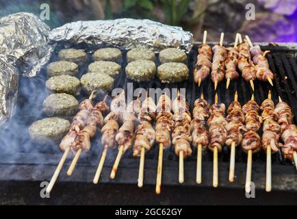 BBQ Burger, gegrillte Herzen auf Spieße und Rauch Grillparty. Nahaufnahme. Stockfoto