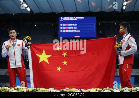 Tokio, Japan. August 2021. Schwimmen: Olympische Spiele, Wasserspringen - Hochtauchen 10m, Männer, Finale im Tokyo Aquatics Center. Der Sieger Cao Yuan (l) und der Vizemeister Yang Jian aus China halten die Flagge ihres Landes. Quelle: Oliver Weiken/dpa/Alamy Live News Stockfoto