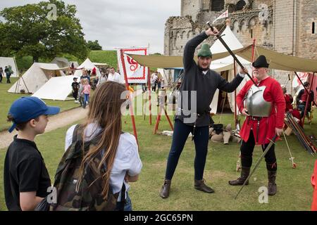 August 2021. Norfolk, England. Soldaten durch die Jahrhunderte Ereignis im Castle Rising, die erste öffentliche Veranstaltung in der Burg aus dem 12. Jahrhundert seit dem Ausbruch der Pandemie von Covid. Mitglieder der mittelalterlichen Kampfkunstgruppe Exiles demonstrieren Besuchern ihre Schwertkünste und ihr breites Wissen über bewaffnete und unbewaffnete Selbstverteidigung. Stockfoto