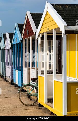 Fahrrad zwischen Strandhütten geparkt. Britische Küste Stockfoto