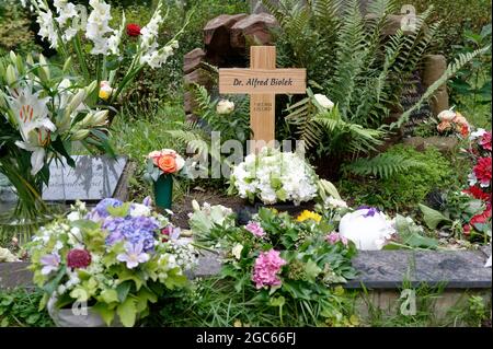 Köln, Deutschland. August 2021. Auf dem Friedhof Melaten steht ein Holzkreuz auf dem Grab von TV-Moderator Alfred Biolek. Die Urne mit Bioleks Asche wurde hier am Freitagabend nach der offiziellen Schließung des Friedhofs mit engen Freunden und Familie begraben. Das Grab gehört der Familie Gruber, mit der Biolek eng befreundet war. Quelle: Henning Kaiser/dpa/Alamy Live News Stockfoto