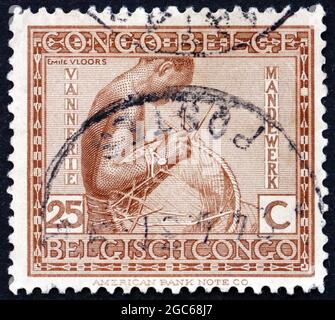 BELGISCHER KONGO - UM 1923: Eine in Belgisch Kongo gedruckte Marke zeigt die Herstellung von Korbwaren, Kunsthandwerk, um 1923 Stockfoto