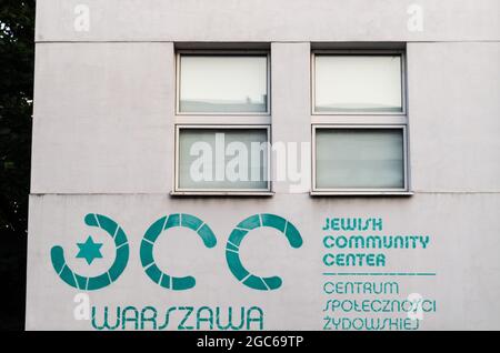 Warschau, Masovia, Polen - 3. Juli 2021: Ansicht des Textes 'JCC WARSZAWA - JÜDISCHES GEMEINDEZENTRUM | Centrum Społeczności Żydowskiej' unter dem Fenster. Stockfoto