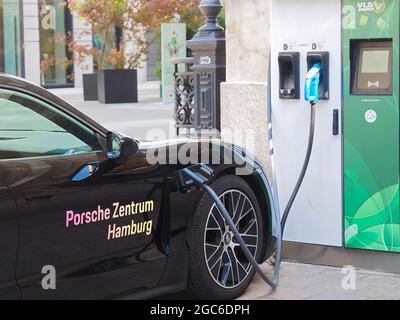 Schwarzes Porsche-Auto an einer elektrischen Ladestation in Hamburg in Deutschland Stockfoto