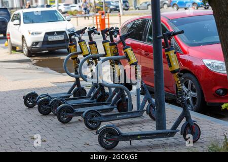 Tula, Russland - 2. August 2021: Elektrische Roller können auf dem Parkplatz gemietet werden. Umweltfreundlicher Sport für den Umzug in die Stadt. Stockfoto