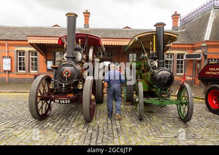 Kidderminster, Worcs, Großbritannien. August 2021. Ein Aussteller der Vintage Transport Extravaganza am Bahnhof Severn Valley, Kidderminster, Worcs, wirft einen Blick auf zwei Dampftraktoren aus den Jahren 1904 und 1914. Kredit: Peter Lopeman/Alamy Live Nachrichten Stockfoto