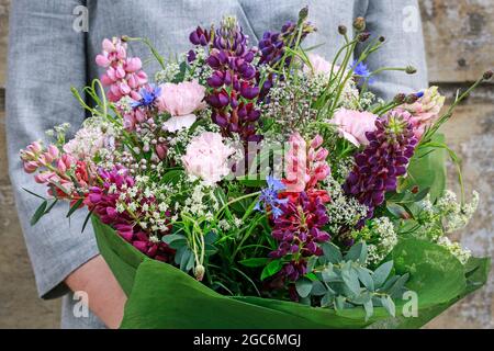 Frau hält einen Blumenstrauß mit Sommerblumen. Gartenhobby Stockfoto