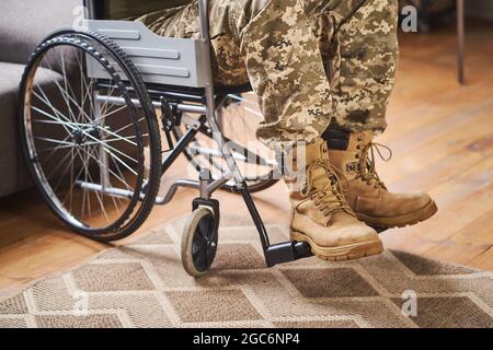 Nahaufnahme der Beine eines Militärs, der in einem Rollstuhl sitzt Stockfoto
