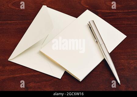 Umschlag und Stift auf Holztisch Stockfoto