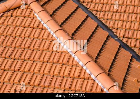 Haus mit neuen Dächern und Fliesen in Form einer gefliesten, doppelschrillen Pavillonlinie Stockfoto