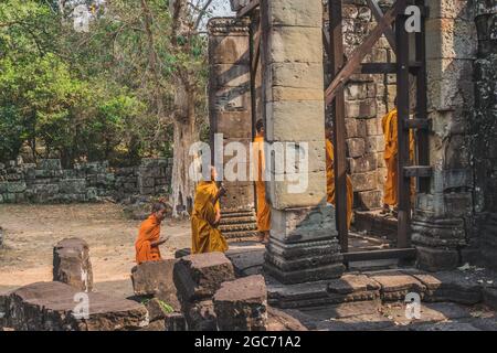 Junge buddhistische Mönche, die in Safranroben im Tempel spazieren und über Angkor Wat blicken. Banteay Kdei Tempel. Siem Reap, Kambodscha - 25. FEBRUAR 2020 Stockfoto