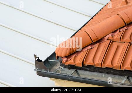 Haus: Detail des Gebäudes mit Dachschräge in Fliesen. Vorhandensein von Gesims mit Rinne für den Abfluss von Regenwasser. Stockfoto