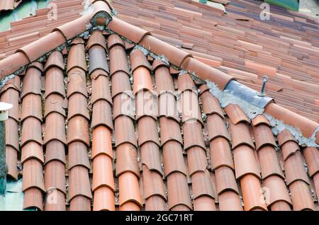 Haus: Schräge Dächer mit Ziegelsteinen, sichtbar die obere Pitch-Linie und die Firstfliesen. Stockfoto