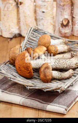 Korb mit Pilzen auf Holztisch. Herbstgemüse Stockfoto