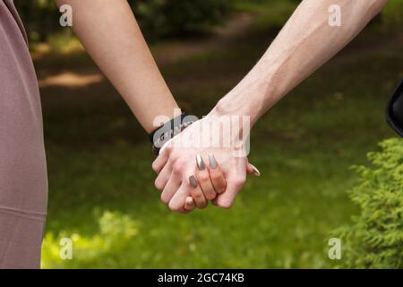 Mann und Frau halten die Hände. Hände aus der Nähe. Am Sommertag draußen Stockfoto