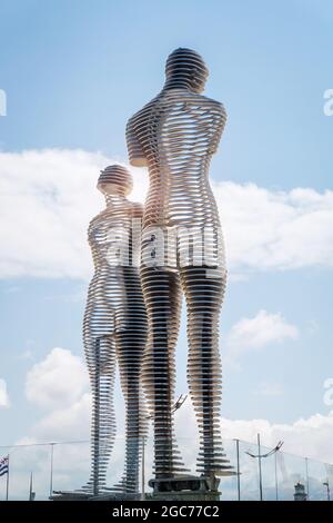 Batumi, Georgia - 2. Juli 2021: Ali und Nino Statue und das Riesenrad in Batumi, Adjara, Georgia. Sich aufeinander zu bewegen berühmte Skulpturen von Mann und Frau in der Liebe. Beliebte Touristenattraktion Stockfoto