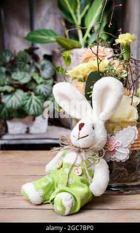 Kaninchen Spielzeug und bunte Blumen. Osterdekoration. Festliche Zeit Stockfoto