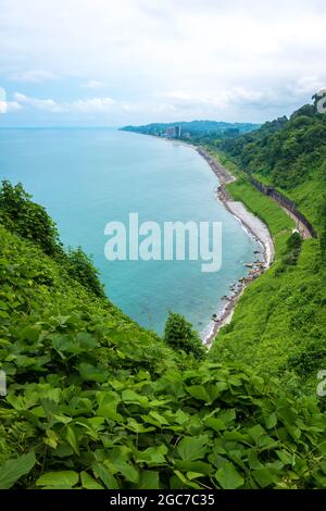 Batumi, Adjara Georgia wunderschöne Schwarzmeerküste mit Eisenbahn und grünem Wald. Blick auf den botanischen Garten auf den Hügel. Sommertag, malerische Landschaft mit blauem Wasser Stockfoto