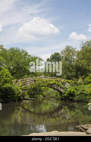 Sommerzeit an der Gapstow Bridge, 1895, von Howard & Caudwall, die über den Teich im südlichen Central Park in der Nähe von Midtown in Manhattan, NYC, geht. Stockfoto