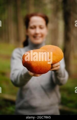 Eine Frau hält essbare Pilze in ihren Händen Stockfoto