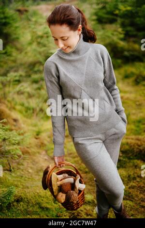 Frau mit einem Korb von Pilzen im Sommerwald Stockfoto