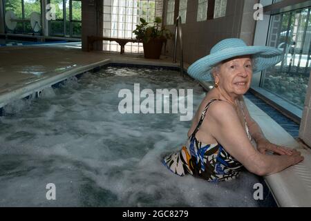 Ältere Frau in ihren 90ern genießt den Whirlpool Stockfoto