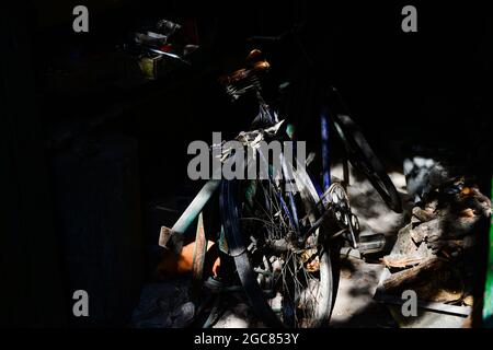 Verlassene Innenraum einer Holzscheune mit einem alten Fahrrad Stockfoto