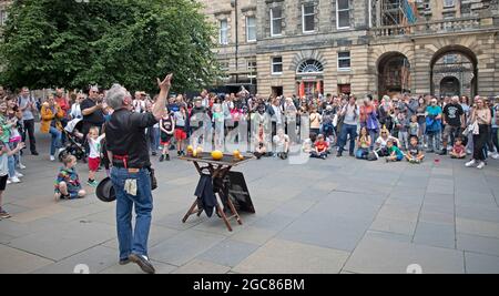Edinburgh, Schottland, Großbritannien. August 2021. Ein geschäftiger Tag für den zweiten Tag des Edinburgh Fringe Festivals in Royal MileJames unterhält ein großes Publikum mit seiner Zaubershow. Am Mercat Cross, Parliament Square. Quelle: Arch White/Alamy Live News. Stockfoto