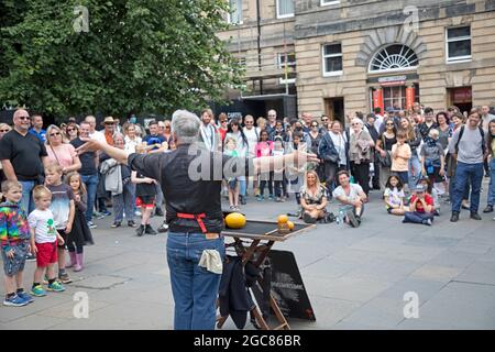 Edinburgh, Schottland, Großbritannien. August 2021. Ein geschäftiger Tag für den zweiten Tag des Edinburgh Fringe Festivals in Royal MileJames unterhält ein großes Publikum mit seiner Zaubershow. Am Mercat Cross, Parliament Square. Quelle: Arch White/Alamy Live News. Stockfoto