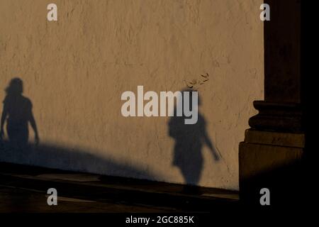 Schatten von Menschen, die im Abendlicht auf die Wand projiziert wurden. Stadt Salvador, Bahia, Brasilien. Stockfoto