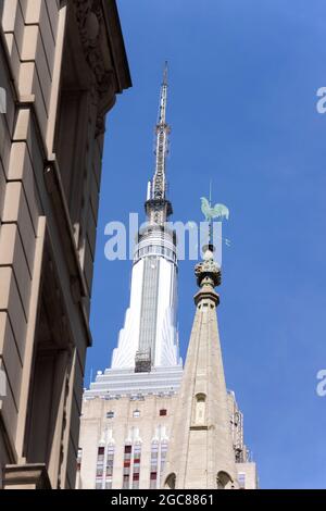 Wetterhahn auf der Marble Collegiate Church, die am 27. März unter blauem Himmel in Midtown Manhattan vor dem Empire State Building steht Stockfoto