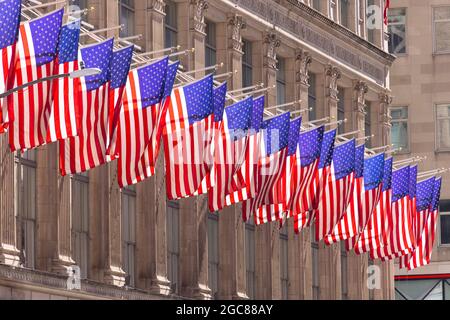 Reihe aufsteigender amerikanischer Flaggen an der Saks Fifth Avenue in Midtown Manhattan am 3 2021. April in New York City, NY, USA. Stockfoto